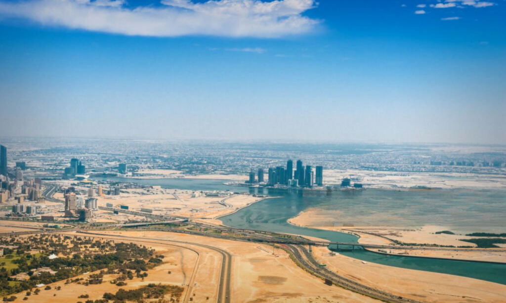 A panoramic view of the Dubai desert with a glimpse of the city skyline.
