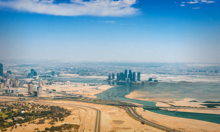 A panoramic view of the Dubai desert with a glimpse of the city skyline.